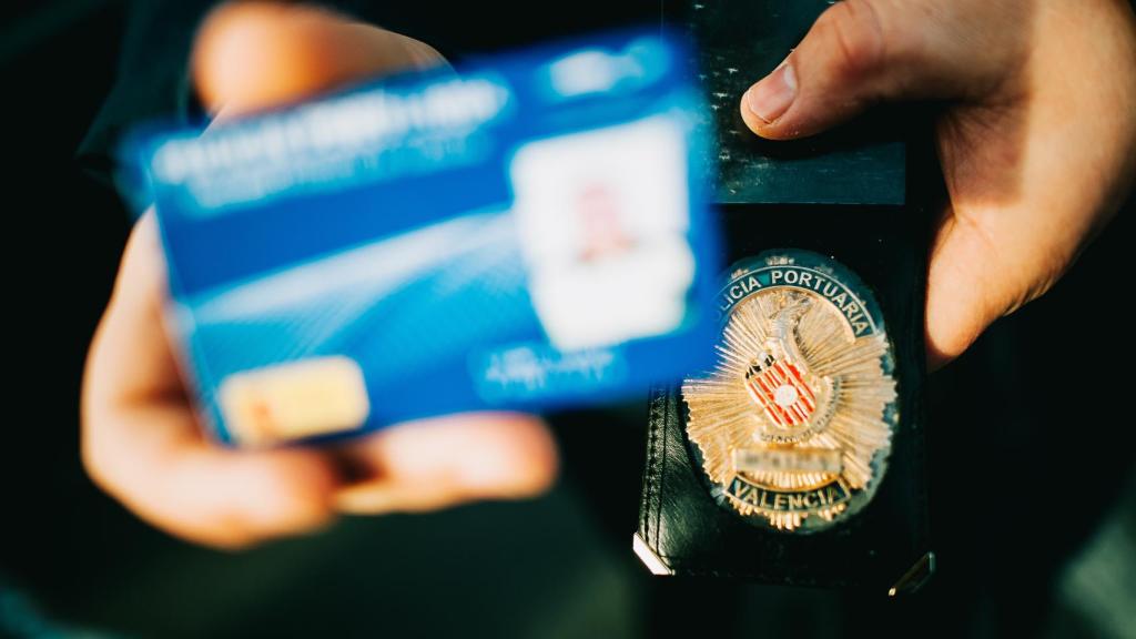 Un policía portuario muestra su placa.