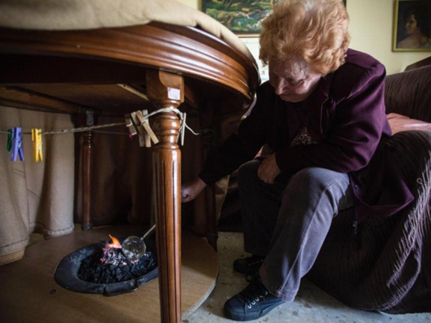 Una mujer prepara un brasero de picón en Sevilla
