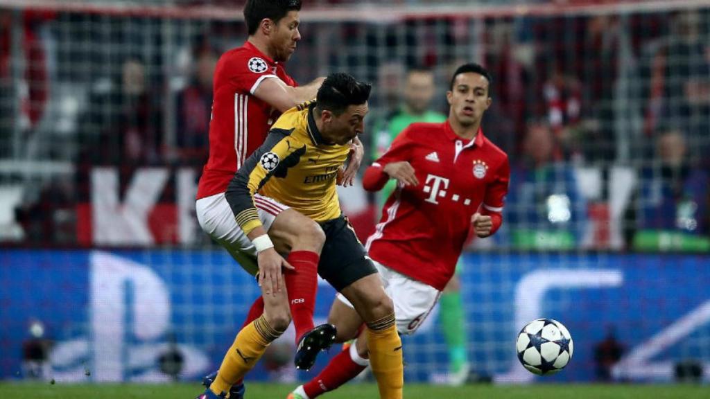 Xabi Alonso pelea un balón frente a Özil en Champions. Foto: fcbayern.com