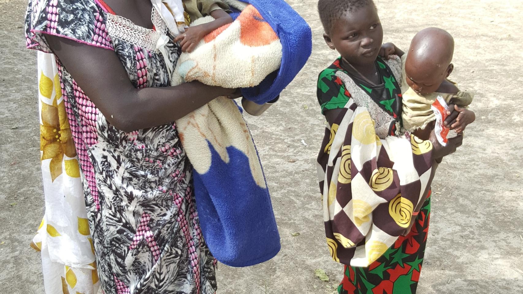Nyayolah posa con sus hijos en un lugar seguro lejos de casa en Sudán del Sur.