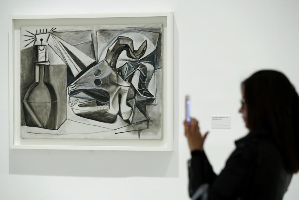 Una visitante frente a la obra de Picasso Cráneo de cabra, botella y vela, en el Museo Reina Sofía.