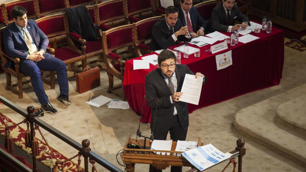 Uno de los participantes enarbola un documento durante su réplica.