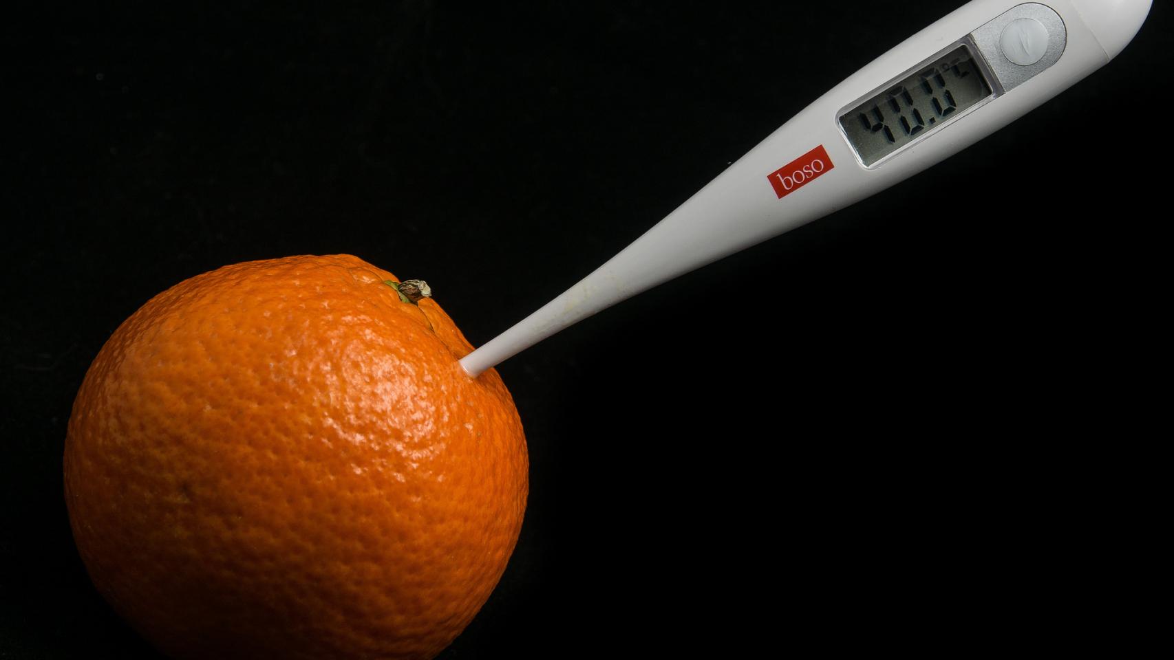 Una mandarina con un termómetro. Menudo bodegón.