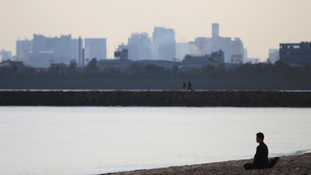 Una persona medita mirando al agua.