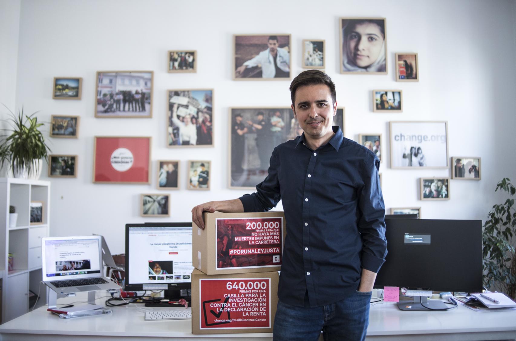 El director de Change.org, José Antonio Ritoré, junto a retratos de los protagonistas del cambio
