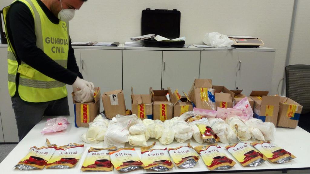 Un agente de la Guardia Civil se pone una mascarilla para manipular la mercancía.