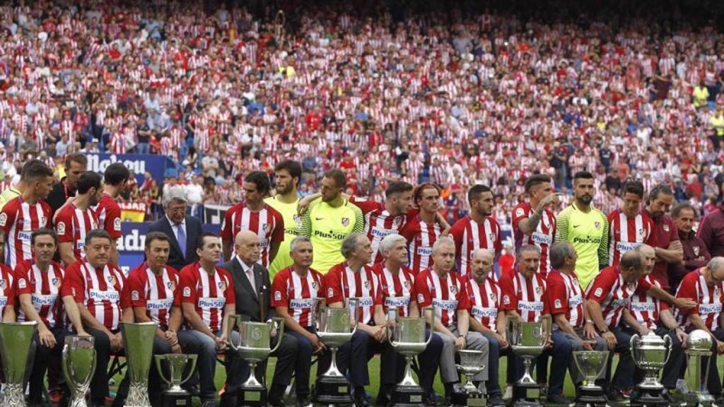 Los veteranos del Atlético de Madrid y los jugadores actuales posan con las copas.