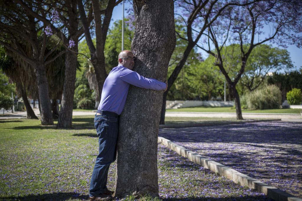 David García, persona con alta sensibilidad, se abraza a un árbol para recuperar energías.