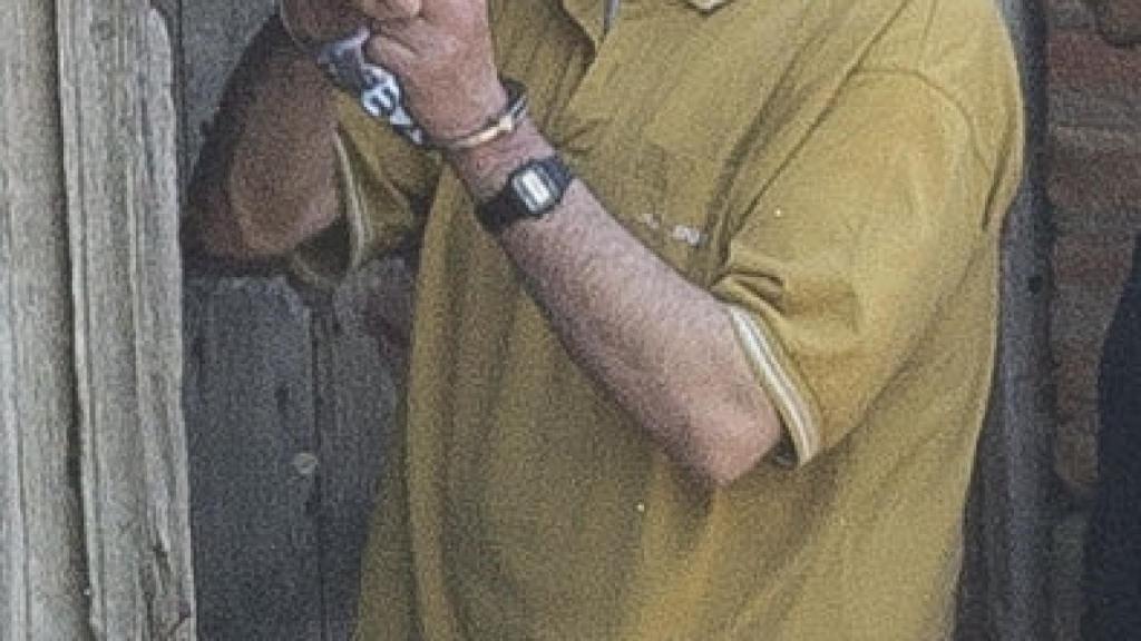 Ángel Ruiz acompañado de un agente policial durante los registros de la semana pasada.