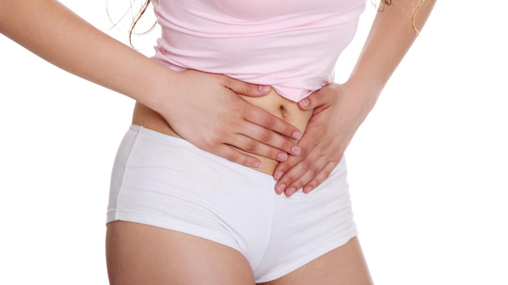 Una mujer pone sus manos sobre la zona en la que están los ovarios.