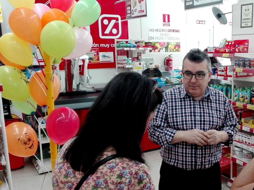 Julián atiende a una de las madres en el supermercado.