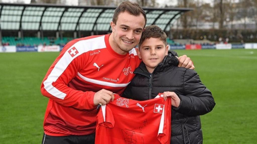 Shaqiri entrega una camiseta de Suiza a un niño. Foto: Twitter (@xs_11official)
