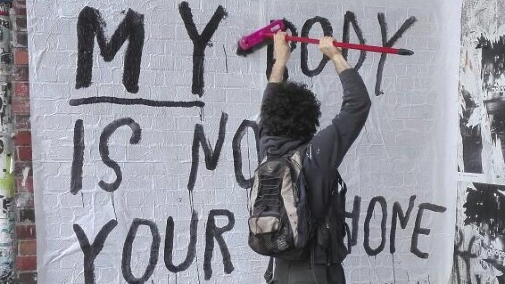 Rallitox pega uno de sus mensajes. My body is not your IPhone o Mi cuerpo no es tu IPhone, se lee.