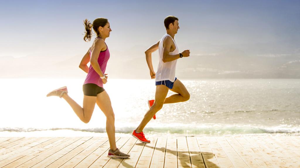 Un hombre y una mujer corren bajo el sol.