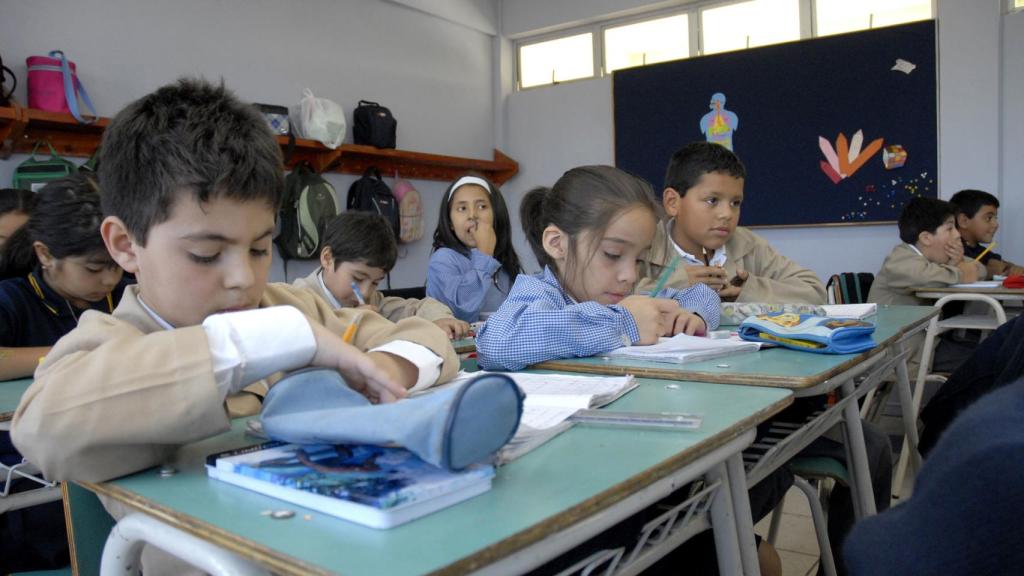 Un grupo de niños asiste a clase en un colegio.
