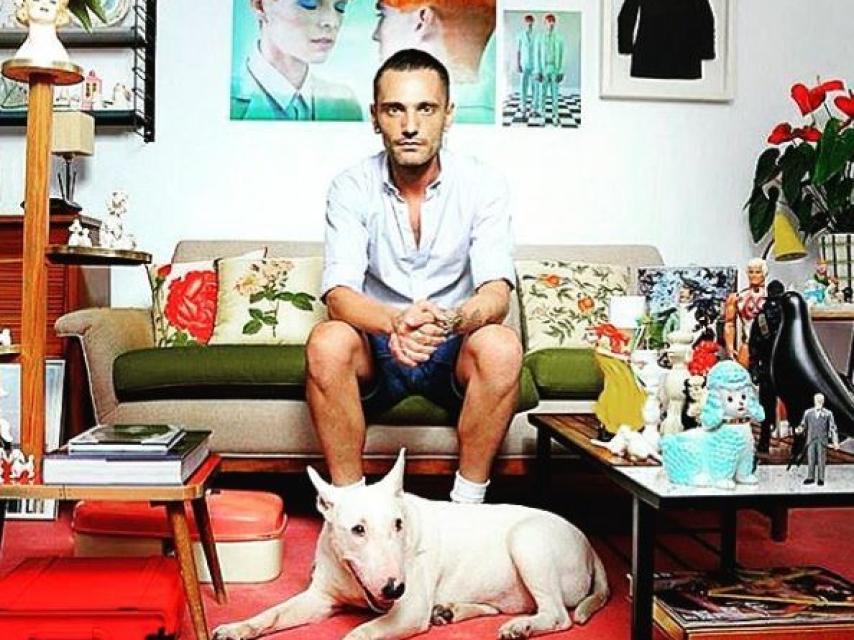 David Delfín en un rincón de su casa posando con su perrita Alice.