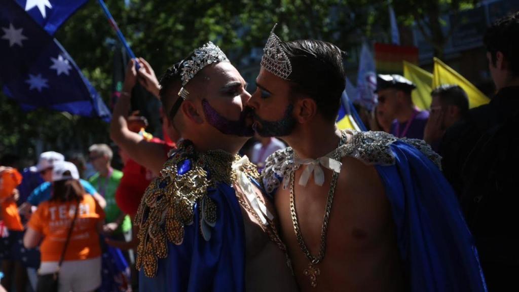 Dos asistentes a la manifestación se besan.