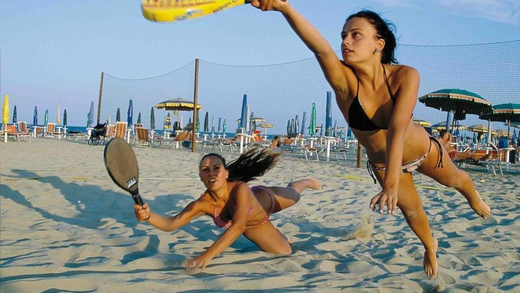 Dos chicas juegan a las palas en la playa.