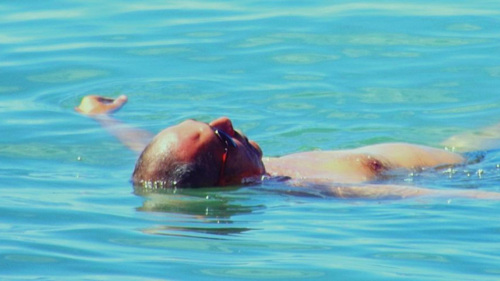 Un hombre flota en el agua.