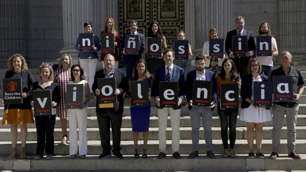 Representantes de todos los grupos parlamentarios posan para la campaña contra la violencia infantil frente al Congreso.