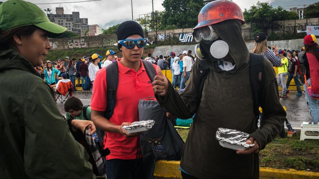 Una voluntaria reparte raciones de comida entre los escuderos.