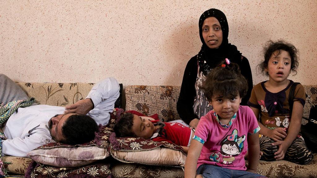 Muhammad, tumbado, Kawtar y sus hijos Hani, Roya y Aya, posan en su casa de Mafraq.