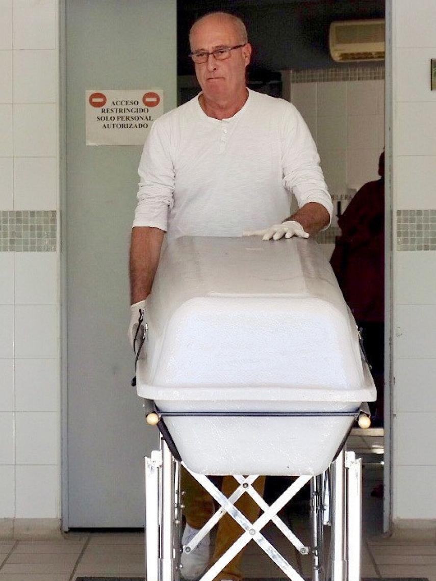 Un operario de la funeraria traslada el féretro con el cadáver de Miguel Blesa a su llegada al Instituto de Medicina Legal en el Tanatorio de la Fuensanta de Córdoba.