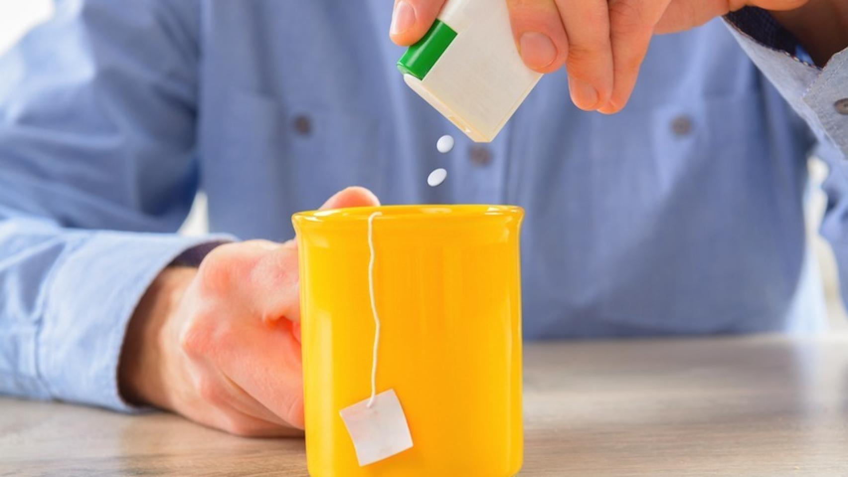 Un hombre le echa edulcorante a su infusión.