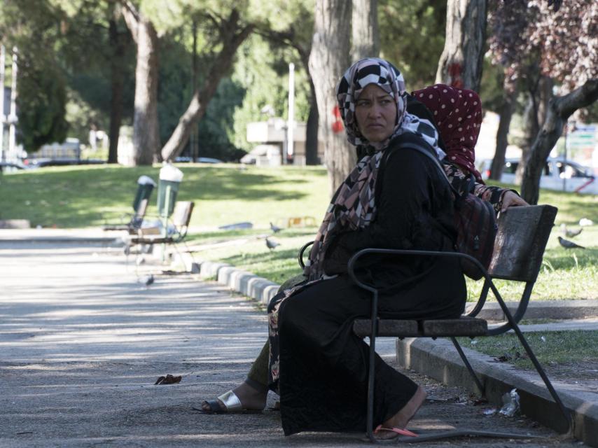 Una mujer observa la llegada del autobús y el movimiento de los periodistas.
