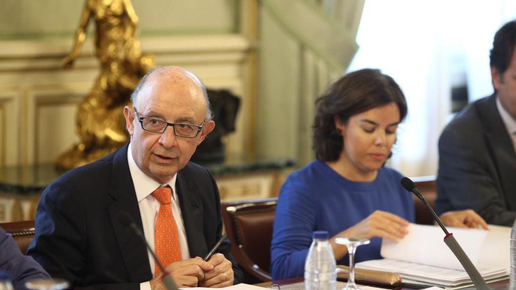 El titular de Hacienda, Cristóbal Montoro, junto a Soraya Sáenz de Santamaría