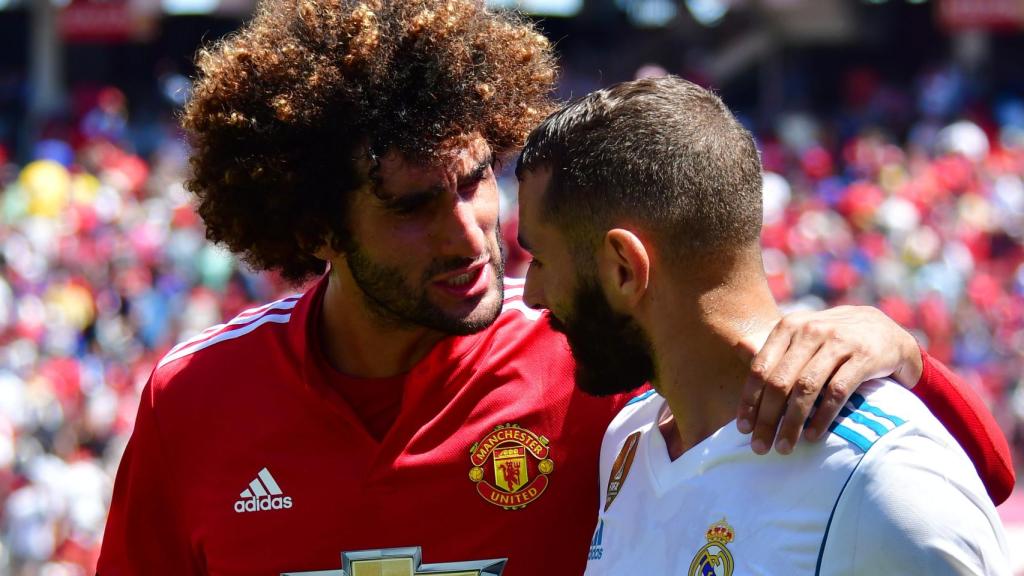 Fellaini y Benzema hablan durante el partido amistoso