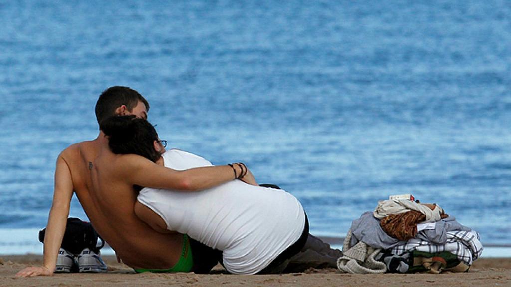 Una pareja disfruta de un día de playa entre arrumacos.