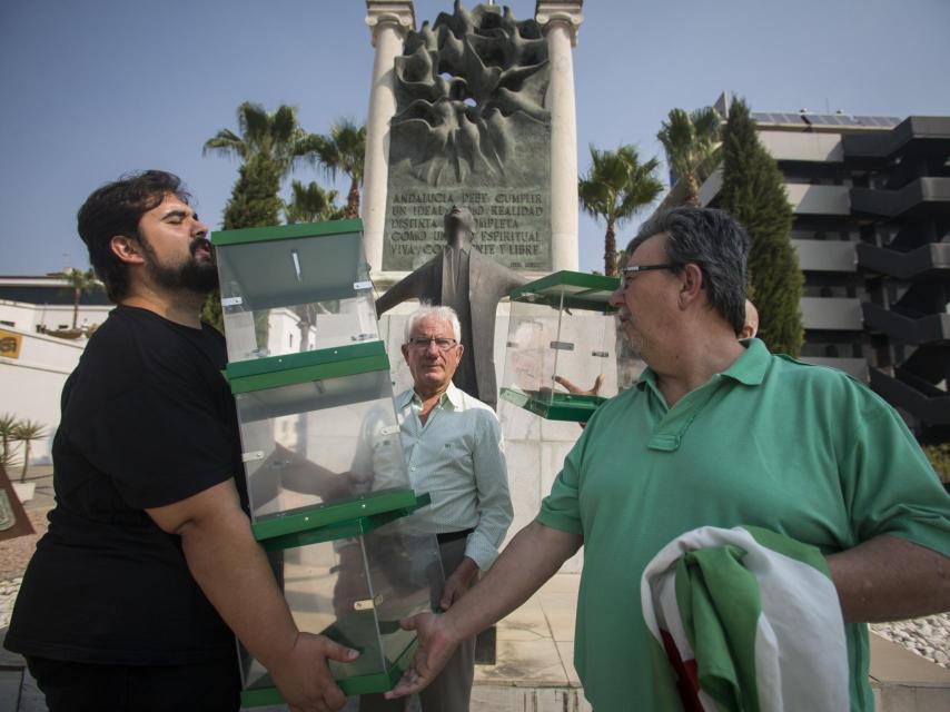 Oscar Reina, portavoz nacional del Sindicato Andaluz de Trabajadores, sostiene unas urnas electorales frente al monumento a Blas Infante en Sevilla.