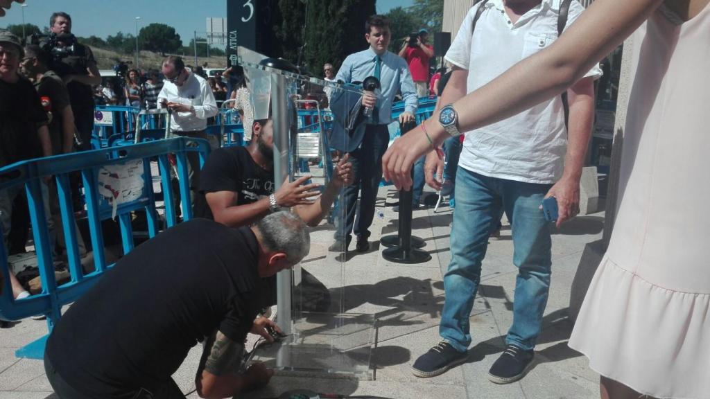 Dos operarios instalan un pequeño estrado a la puerta del juzgado para que Cristiano se dirija a la prensa tras su declaración.