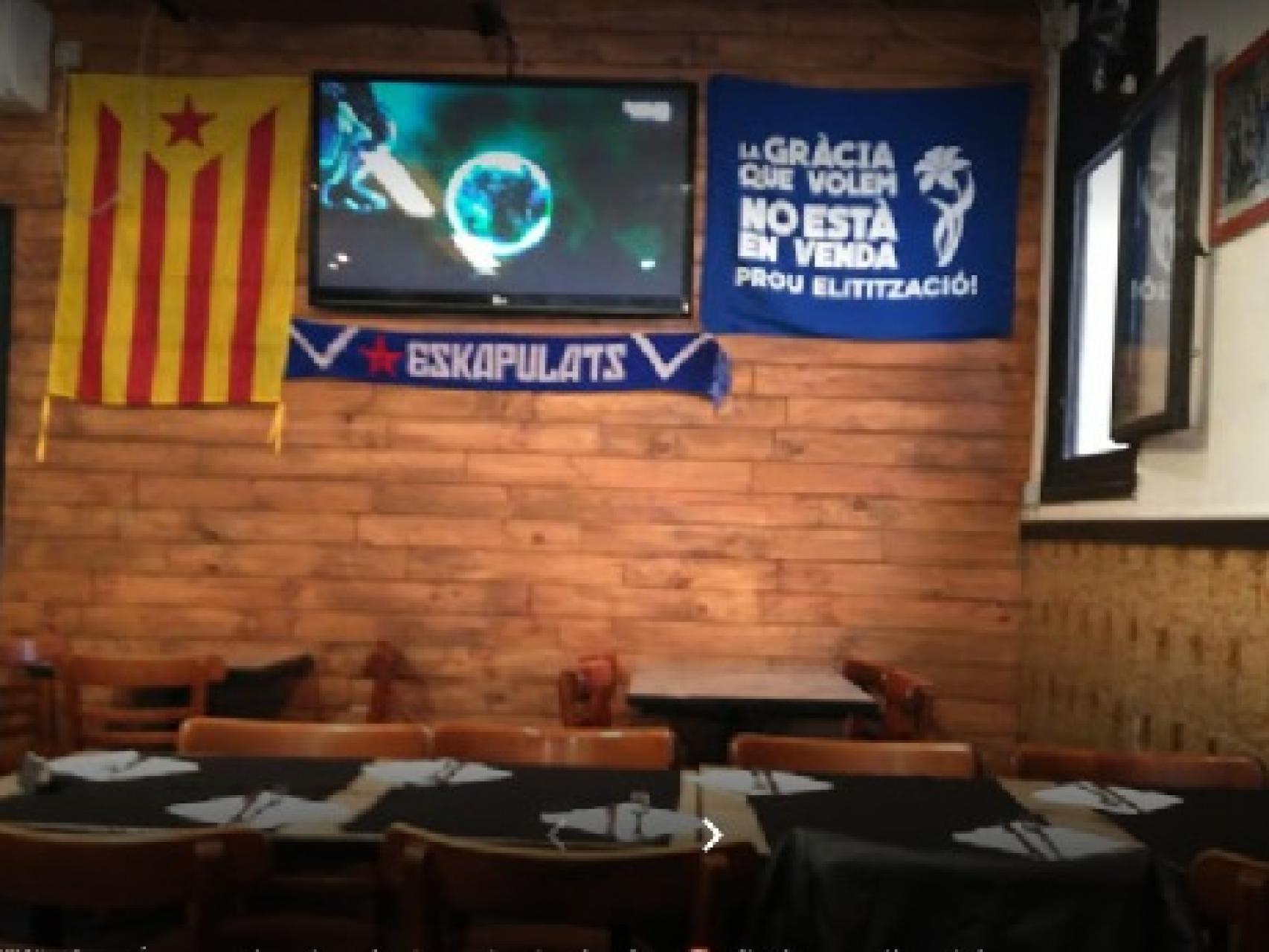 El interior de La Barraqueta, con una estelada y una pancarta reivindicativa del barrio de Gràcia