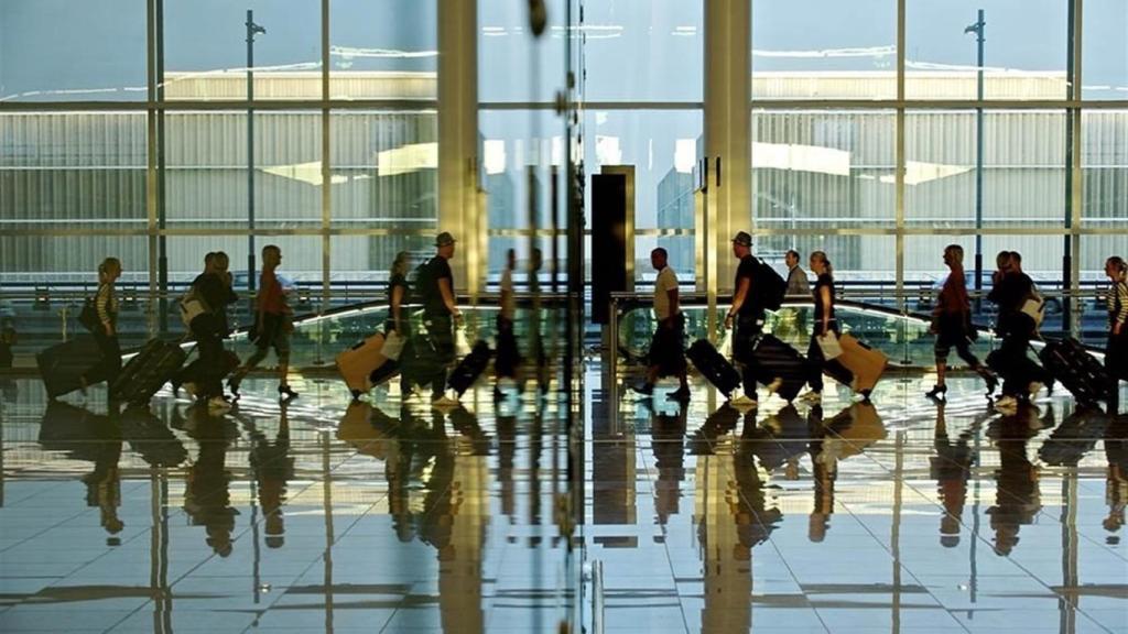 Imagen de pasajeros en tránsito en un aeropuerto.