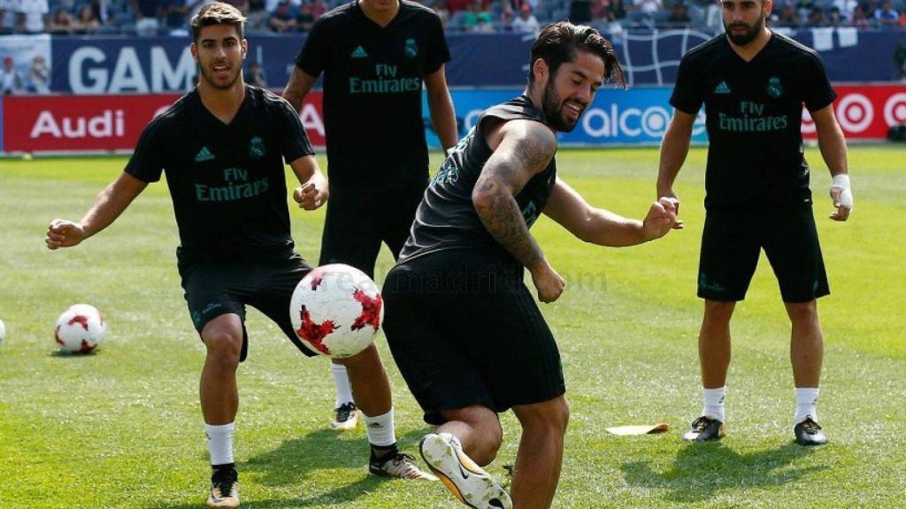 Isco controla un balón ante la mirada de sus compañeros