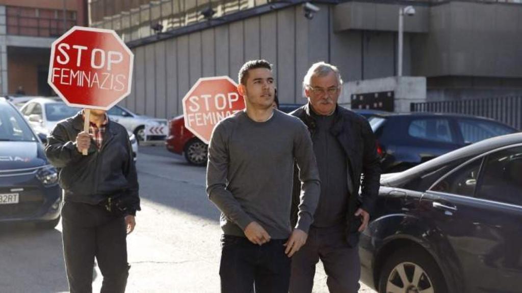 Lucas Hernández llegando a los juzgados escoltado por hombres con pancartas de Stop feminazis.