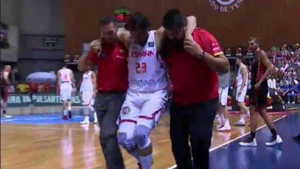 Llull abandona la pista ayudado por los médicos de la selección.