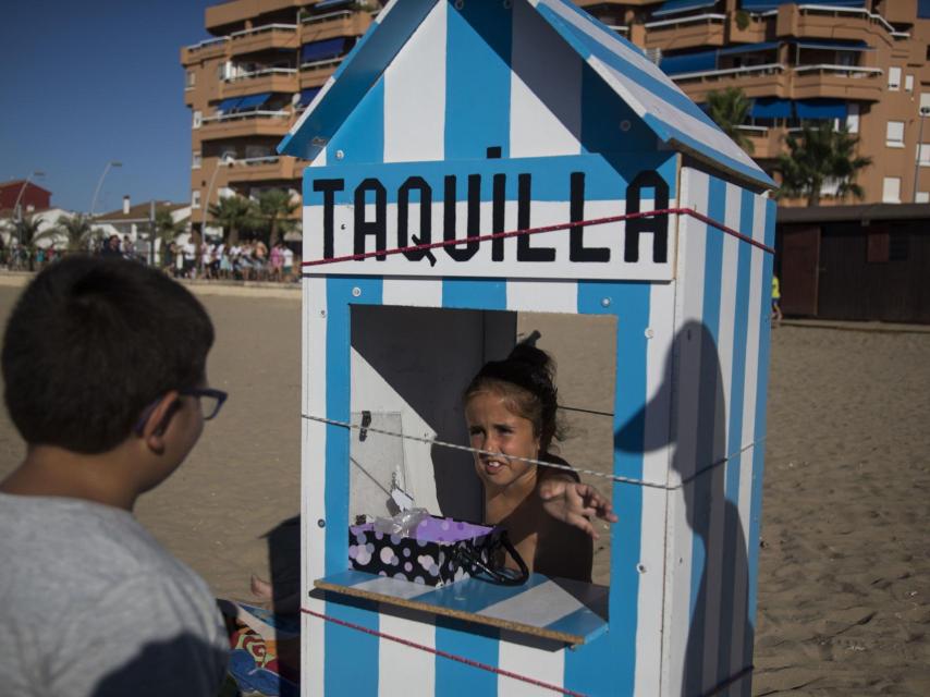 Maravillas, de 9 años, con su caseta de tickets para apostar en la carrera. Gana quien adivina el caballo que pasará primero ante su caseta.