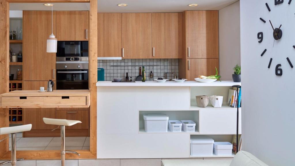 Esta cocina abierta aprovecha la mesa de comedor como isla y, además, dispone abajo estanterías para almacenar. | Foto: Leroy Merlin.