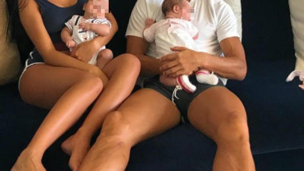 El futbolista posa con uno de sus bebés en brazos. Su novia, con el otro. Detrás de ellos, Ronaldo Jr.