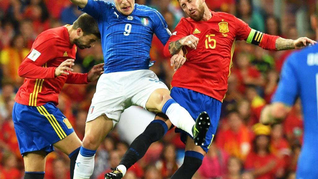 Ramos y Piqué disputan un balón con Belotti.