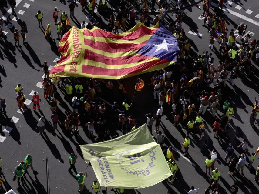 Manifestantes en la Diada despliegan una bandera catalana independentista.