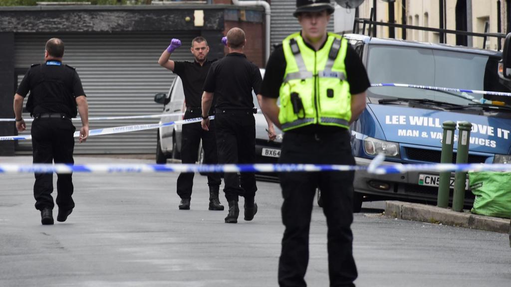 Aagentes detrás del cordón policial tras la detención en Newport.