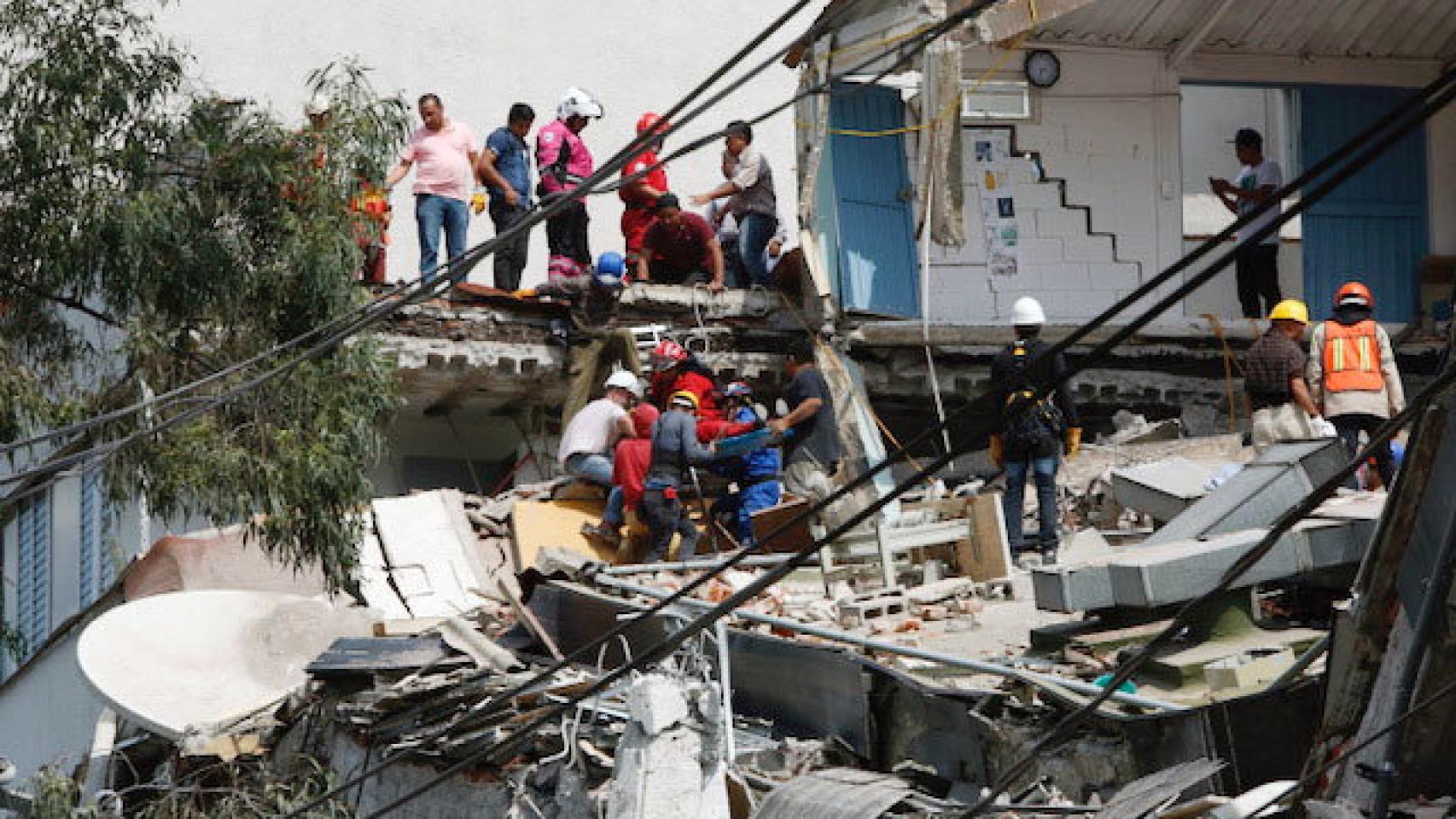 Equipos de emergencia sacan a un herido de los escombros.