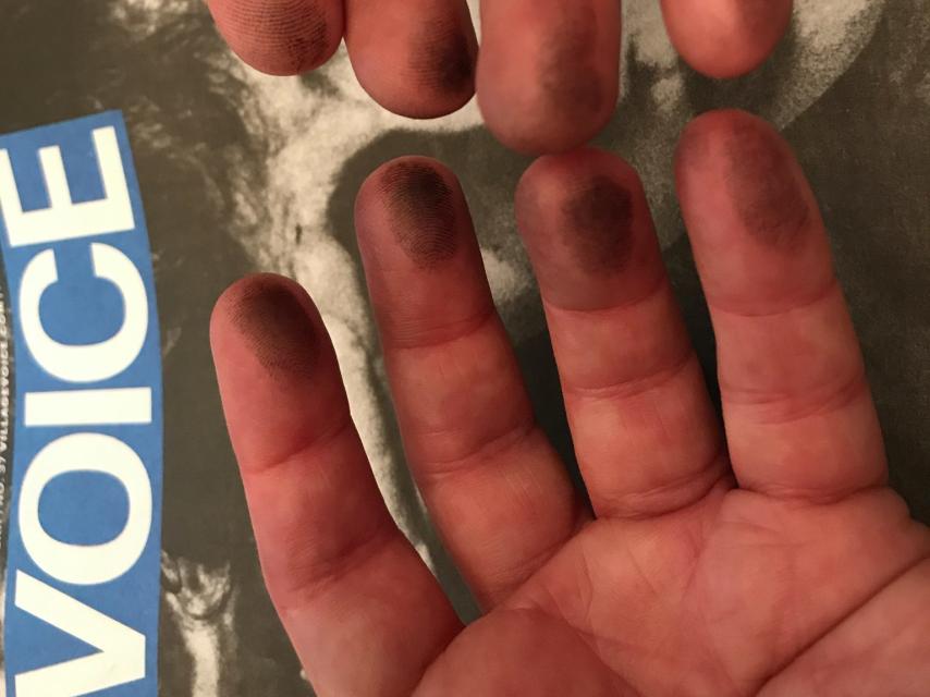 Las manos con tinta de Jeff Weinstein sobre el último ejemplar.