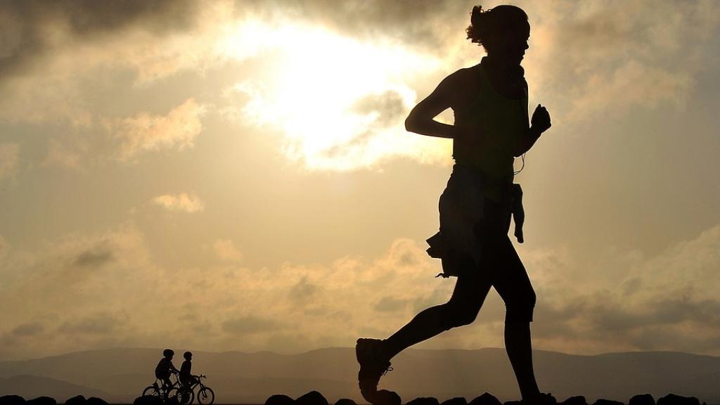 Una señorita realizando carrera continua al atardecer.