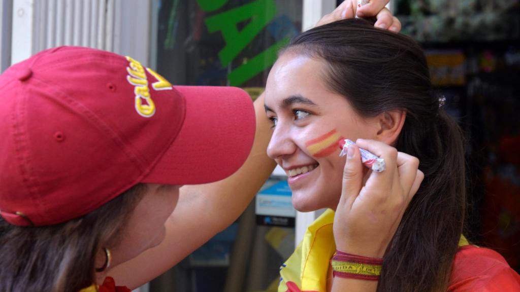 Una joven se pinta la bandera española en la cara.