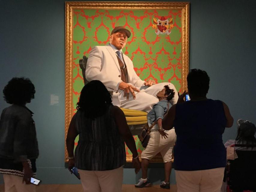 Varios visitantes ante una de las obras de Kehinde Wiley.